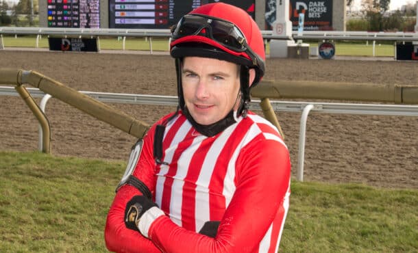 A jockey wearing red-and-white silks.