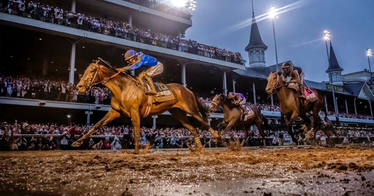 Horses racing in the mud at Churchill Downs.
