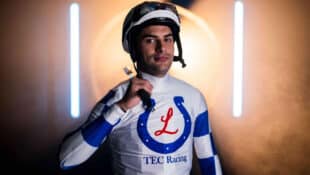 A jockey wearing white-and-blue racing silks.