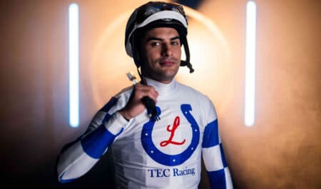 A jockey wearing white-and-blue racing silks.