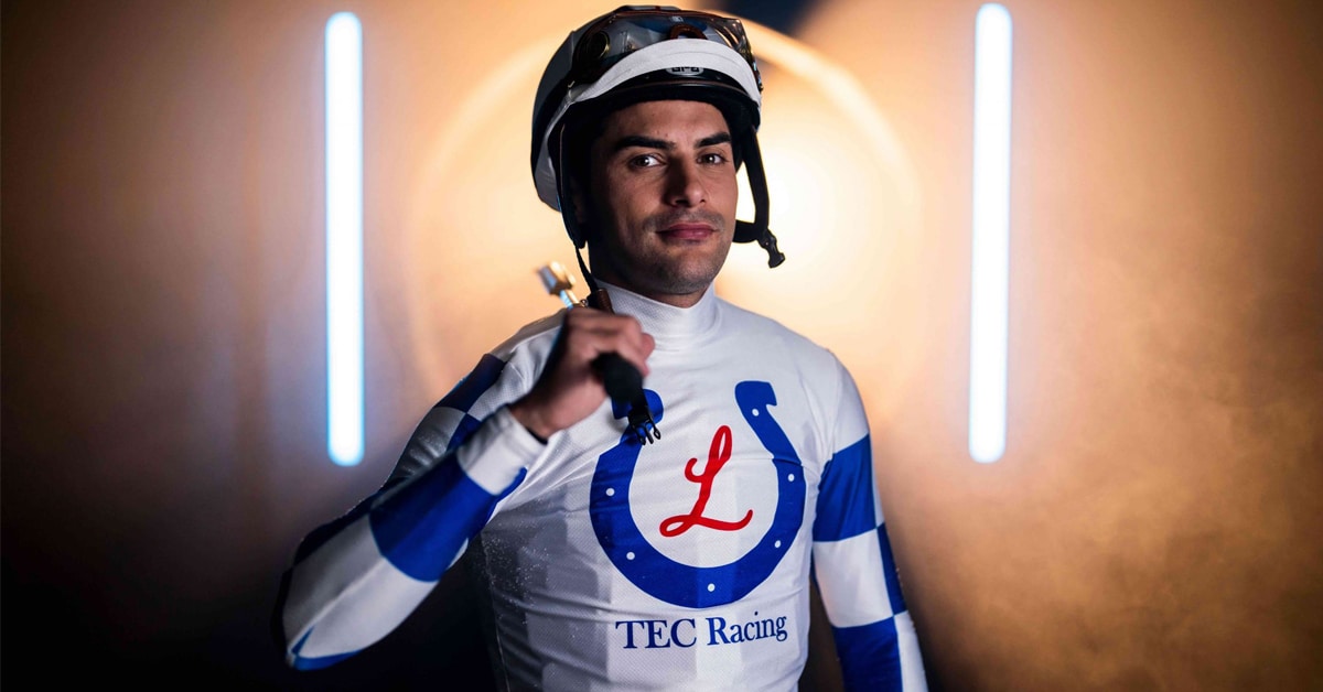 A jockey wearing white-and-blue racing silks.