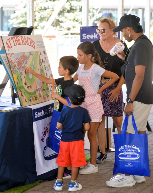 Kids looking at a board with racing info.