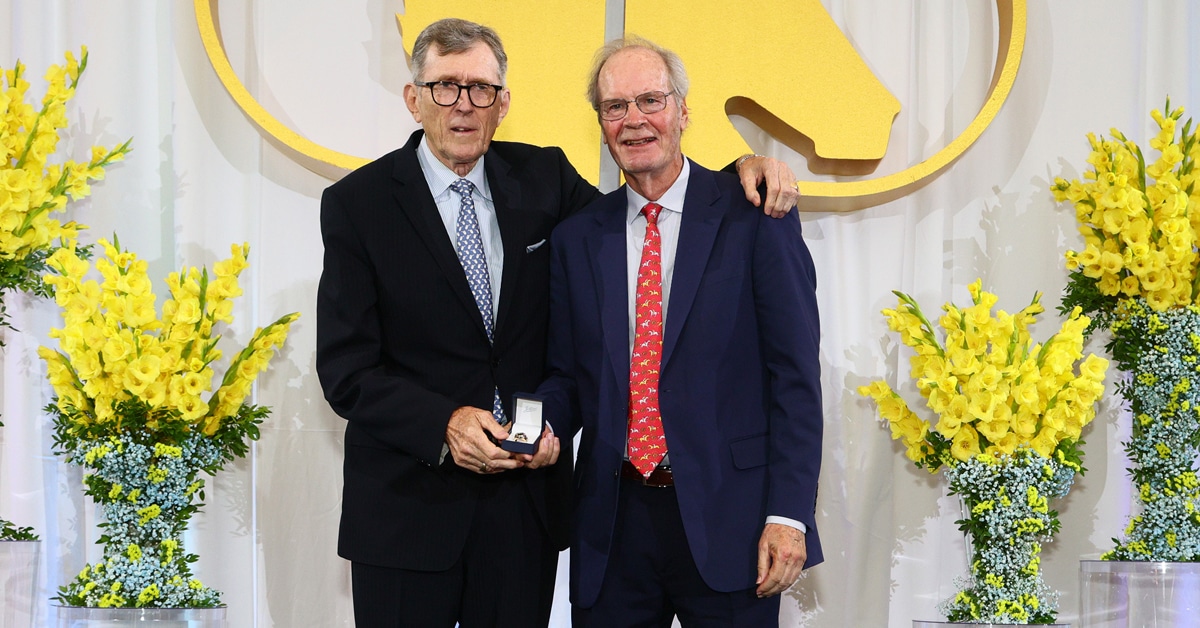 A man handing another man an award on stage.