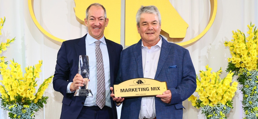 A man being presented a trophy on stage.