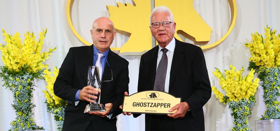 A man holding a Ghostzapper sign, receiving an award.