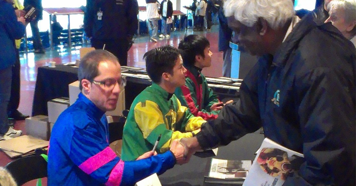 Three jockeys sitting at a table.