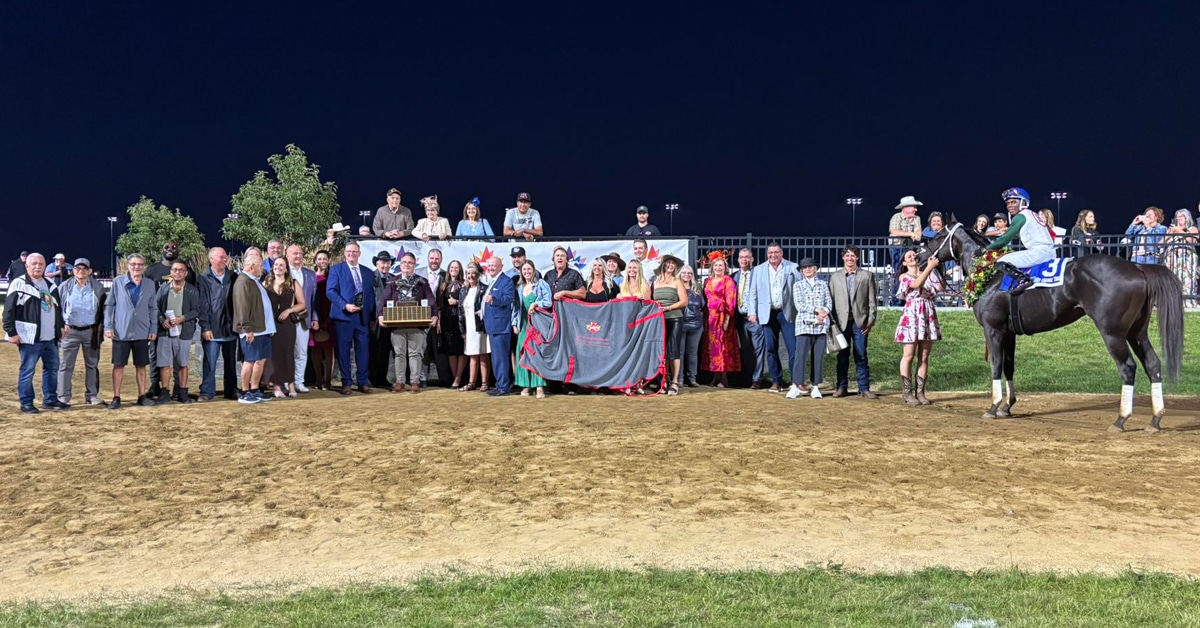 A large group of people with a winning horse in the winners circle.