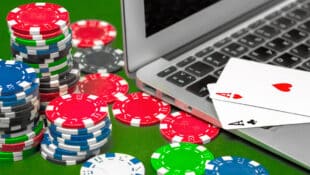 Poker chips, playing cards and a laptop.