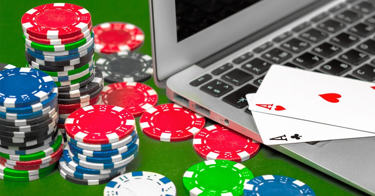 Poker chips, playing cards and a laptop.