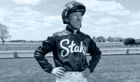 A jockey standing with hands on hips.