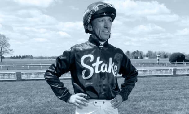 A jockey standing with hands on hips.