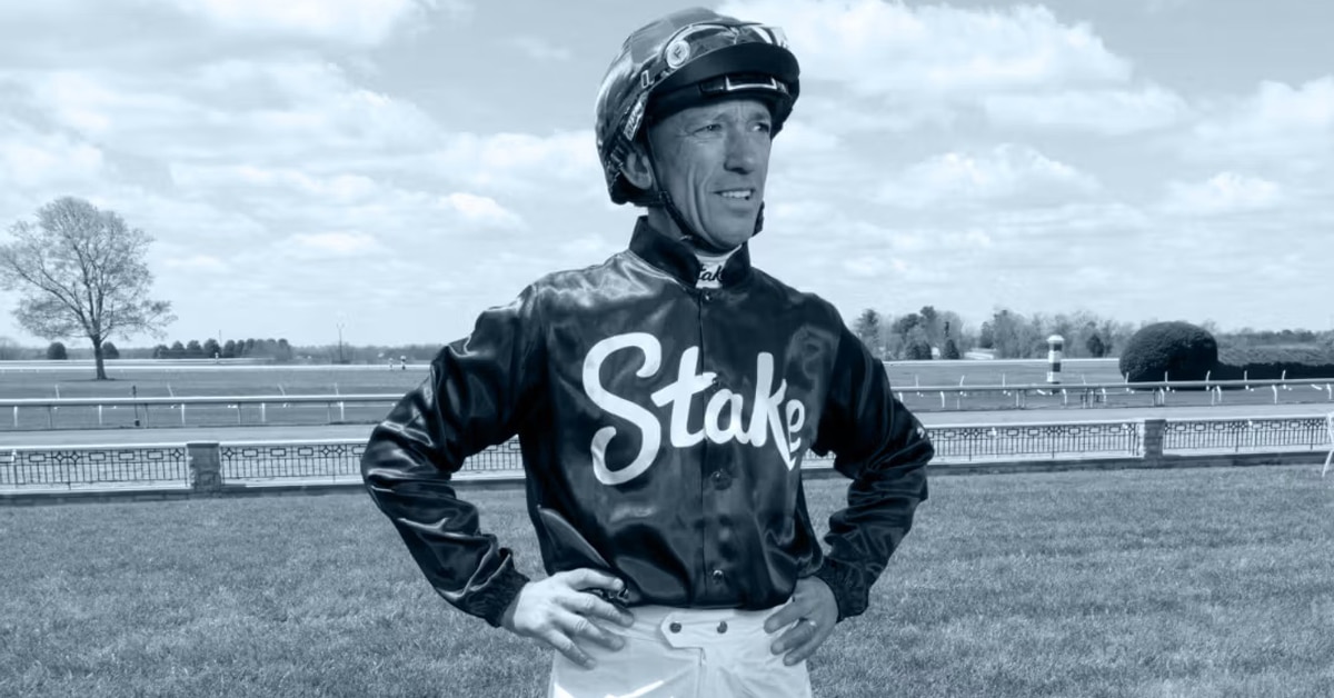 A jockey standing with hands on hips.