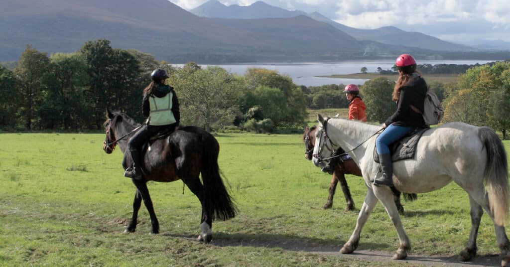 People riding horses in Ireland.