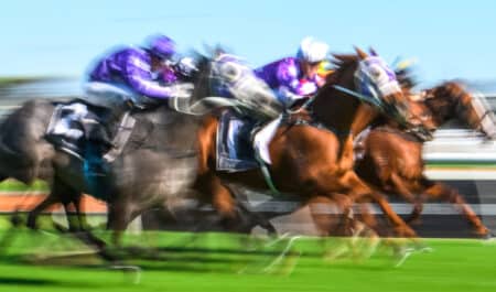 A blurred photo of horses racing.