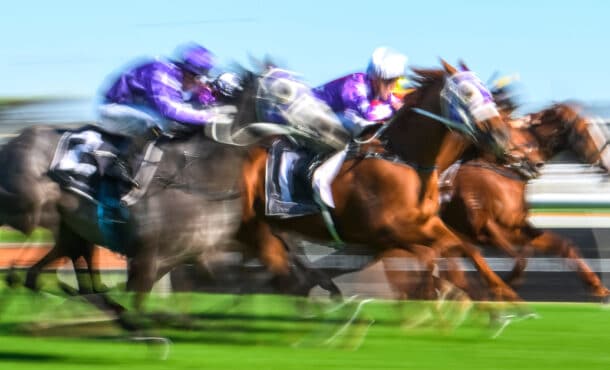 A blurred photo of horses racing.