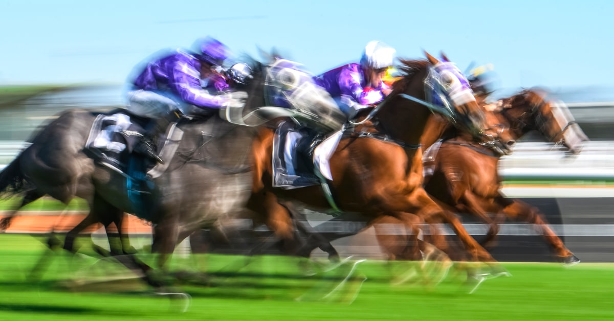 A blurred photo of horses racing.