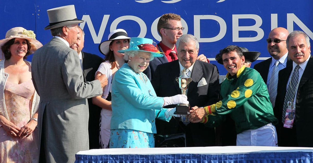 A group of people with a trophy in the winners circle at Woodbine.
