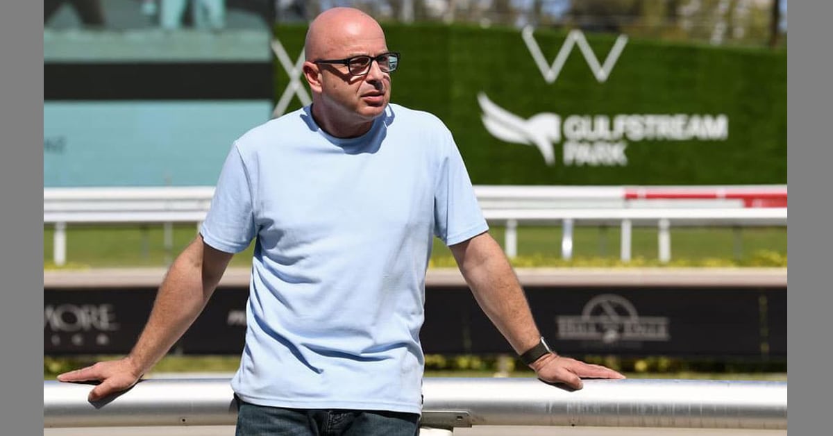 A man in a blue t-shirt standing trackside at Gulfstream.