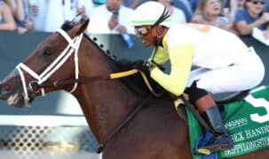 A man riding a bay racehorse at Oaklawn.