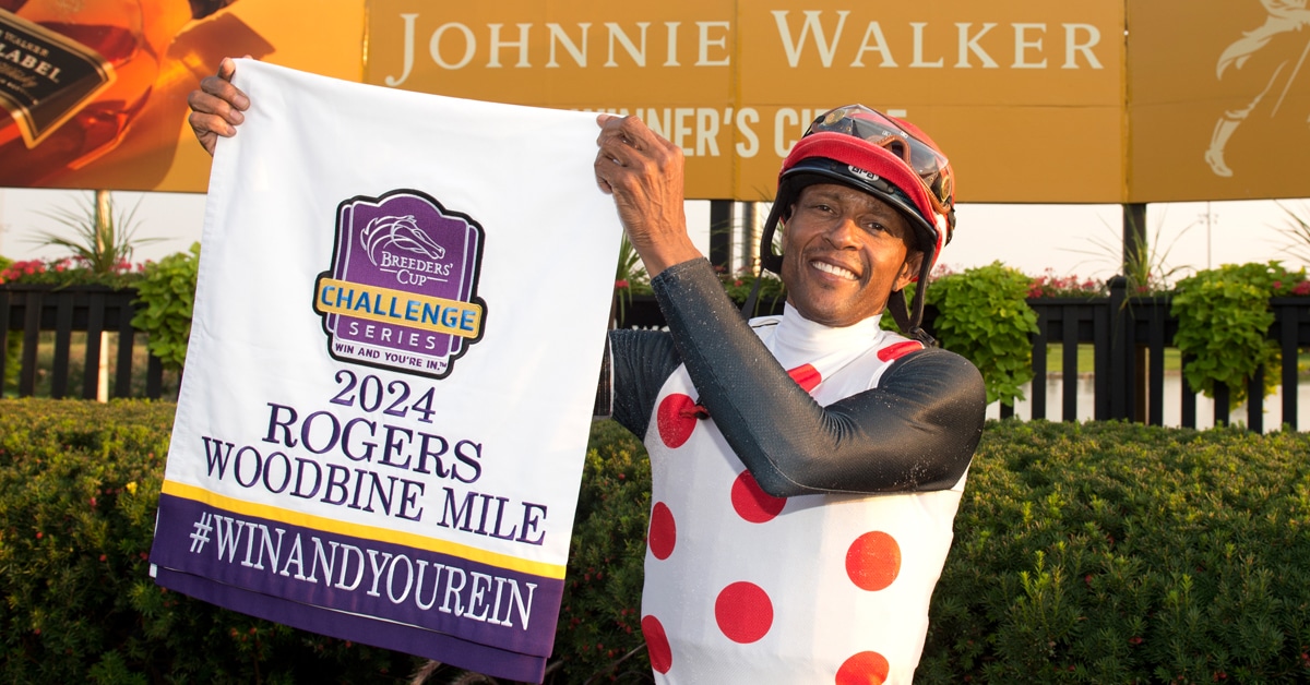 A jockey holding up a Woodbine Mile banner.
