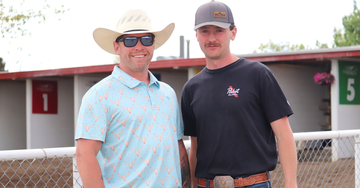 Two smiling men at an Alberta racetrack.
