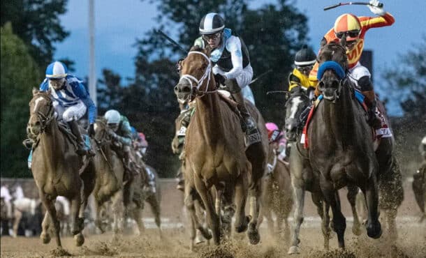 Head-on shot of horses racing at Churchill Downs.