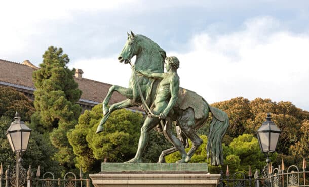 A statue of a man leading a rearing horse.