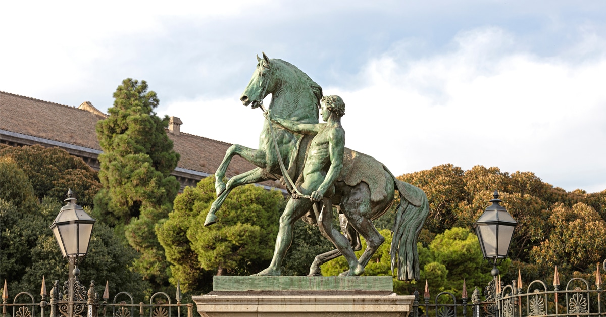 A statue of a man leading a rearing horse.