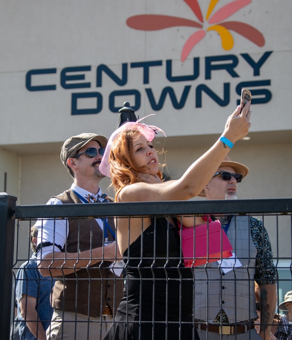 A woman taking a selfie at a racetrack.